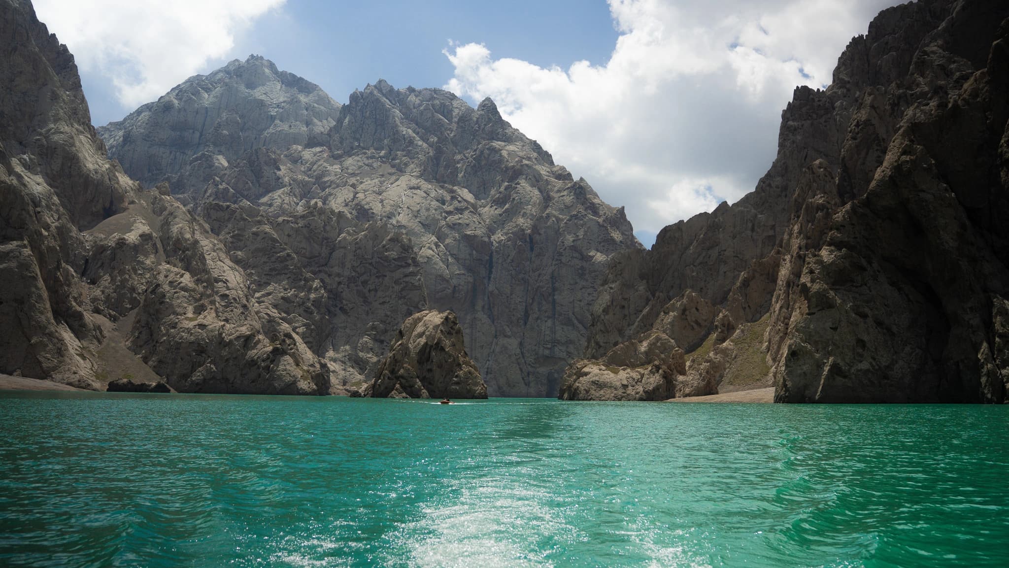 Turquoise glacial lake in dramatic red canyon