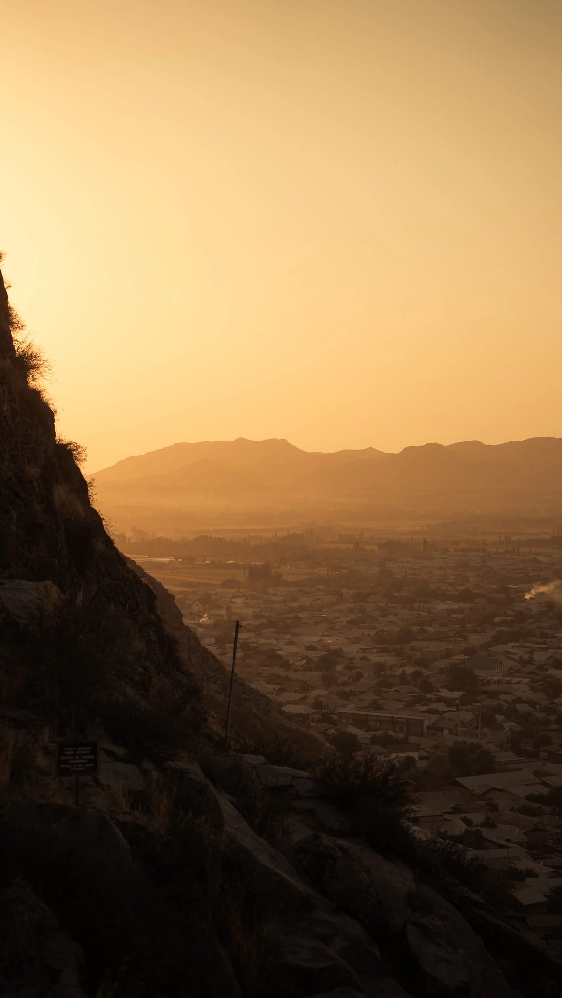 Osh en de omliggende bergen vanaf Sulaiman-Too rond zonsondergang