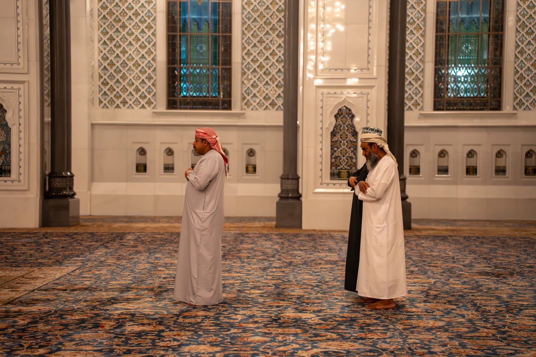 Men praying together inside Sultan Qaboos Grand Mosque