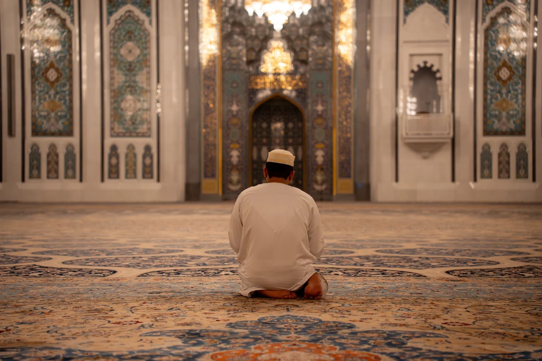 Man praying in Sultan Qaboos Grand Mosque